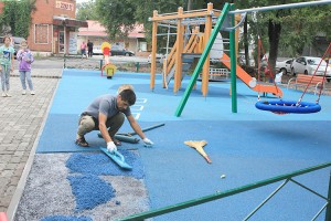 Последние метры мягкого покрытия - и детская площадка готова